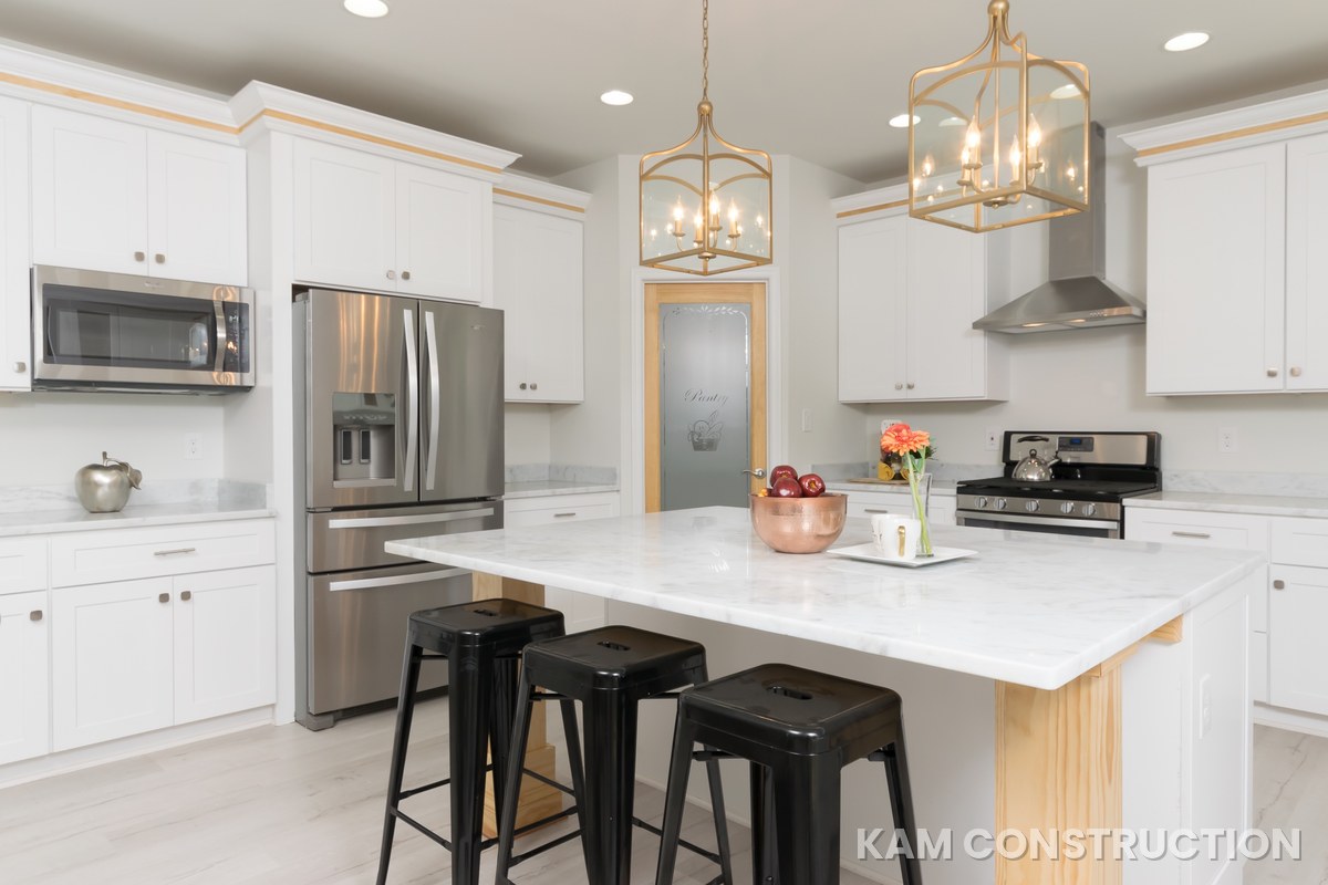 White kitchen with gold accents and island seating