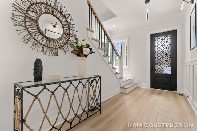 Modern farmhouse foyer with round mirror and staircase